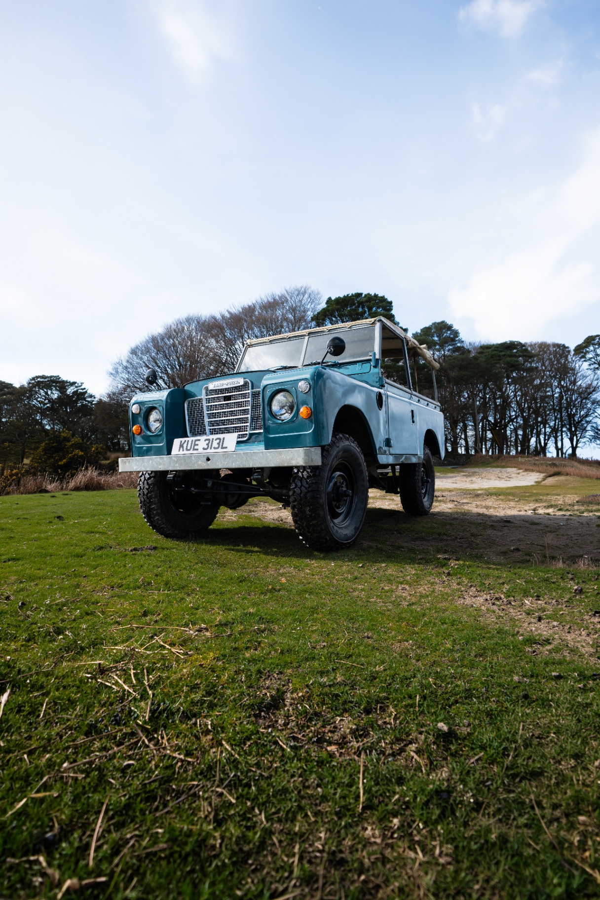 Land Rover Series III in blue, on a coastal grass clearing